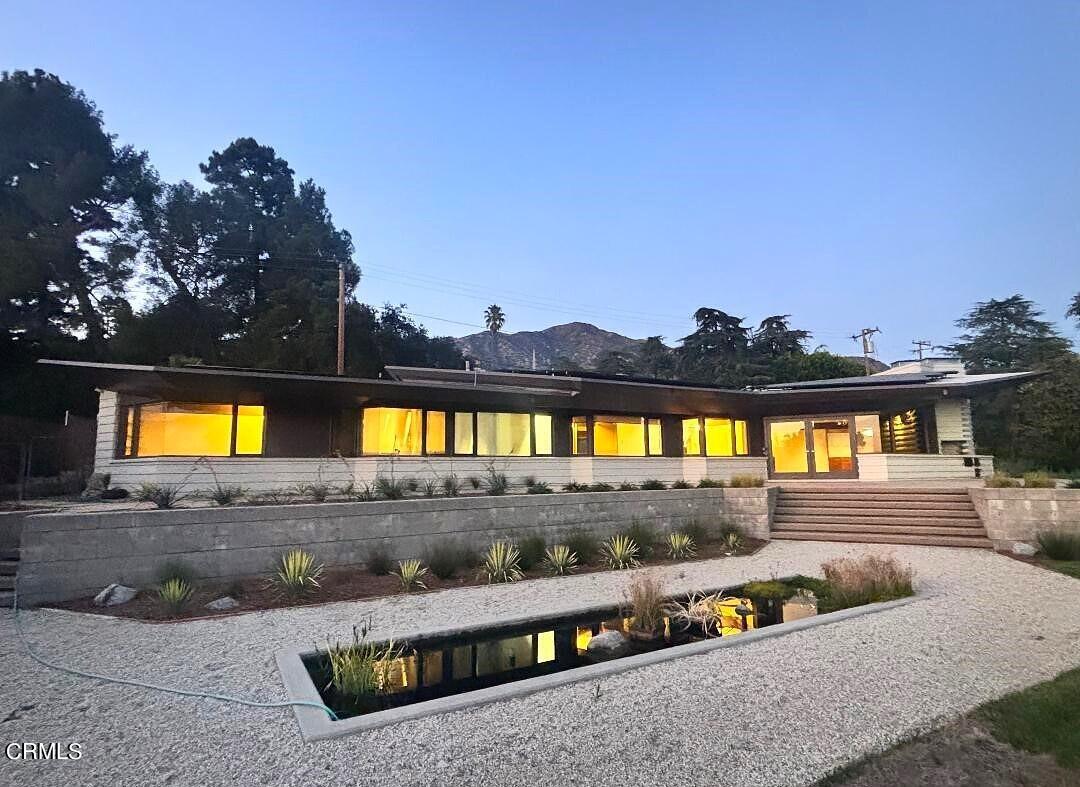 a view of a house with swimming pool and a yard