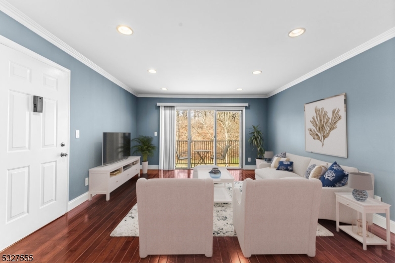 a living room with furniture wooden floor and a flat screen tv