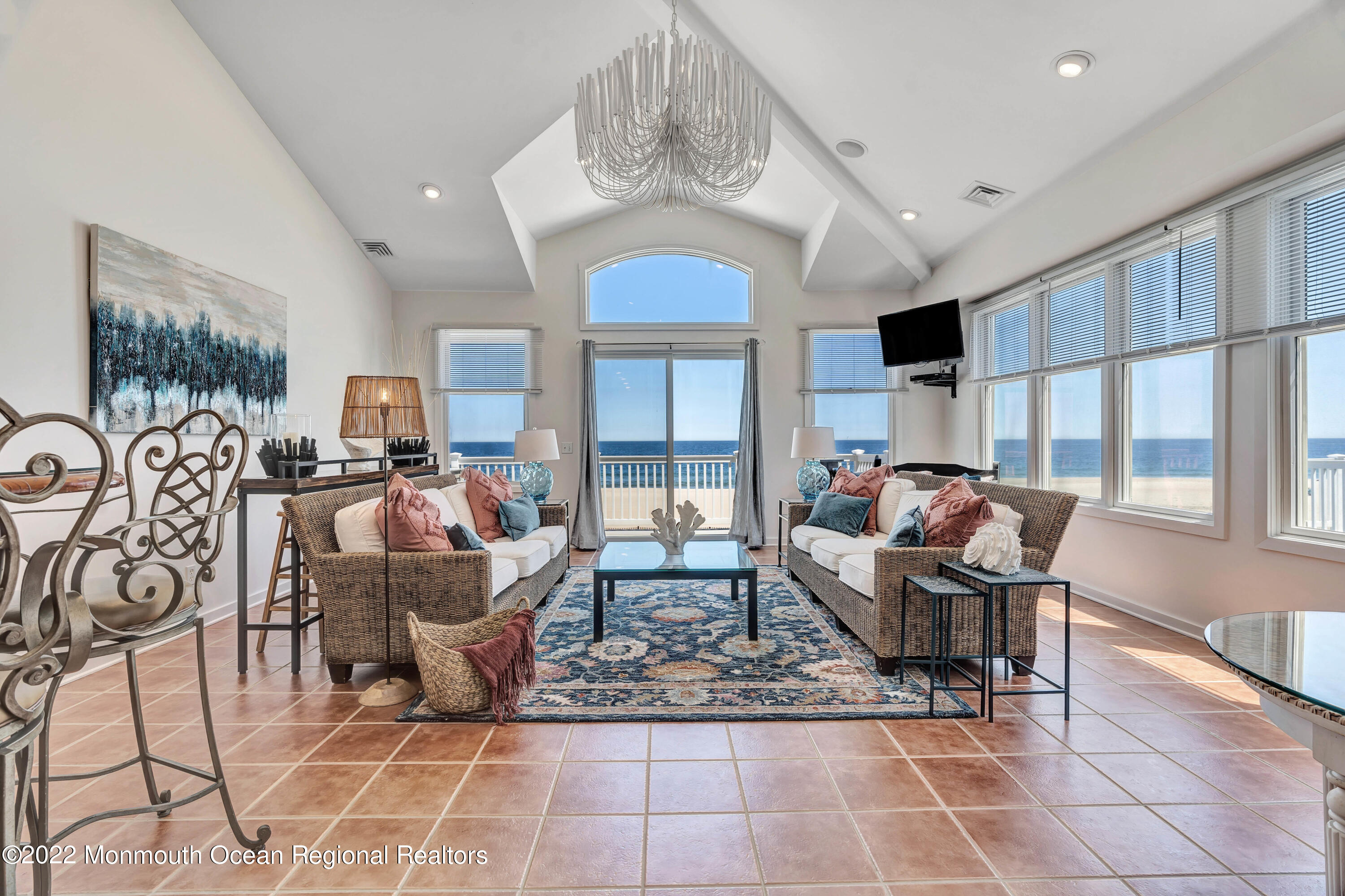 a living room with furniture a chandelier and a floor to ceiling window