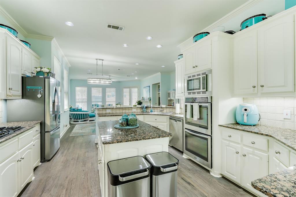 a kitchen with stainless steel appliances granite countertop a stove refrigerator and cabinets