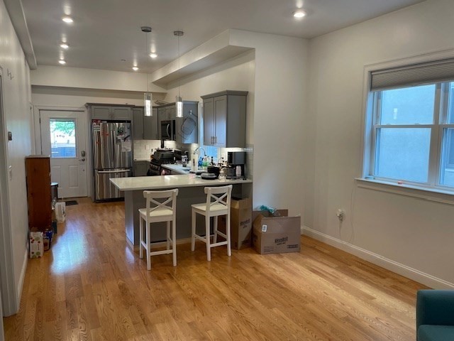 a kitchen with stainless steel appliances dining table chairs and wooden floor