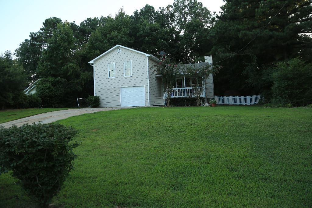 Estate size lot with rocking chair front porch and white picket fence back yard