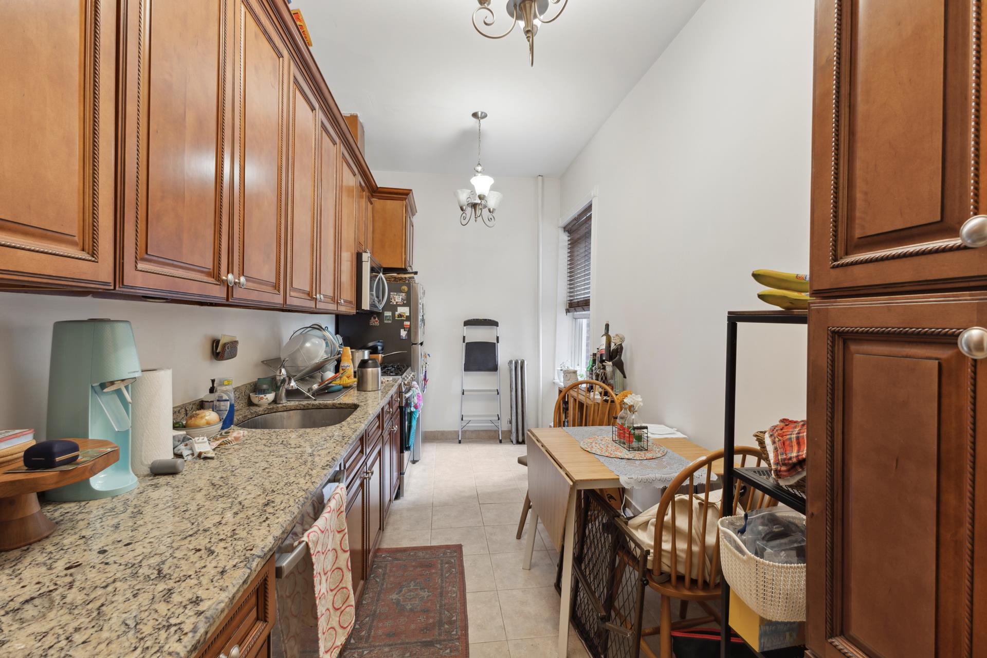 a kitchen with stainless steel appliances granite countertop a sink a stove and a wooden floors