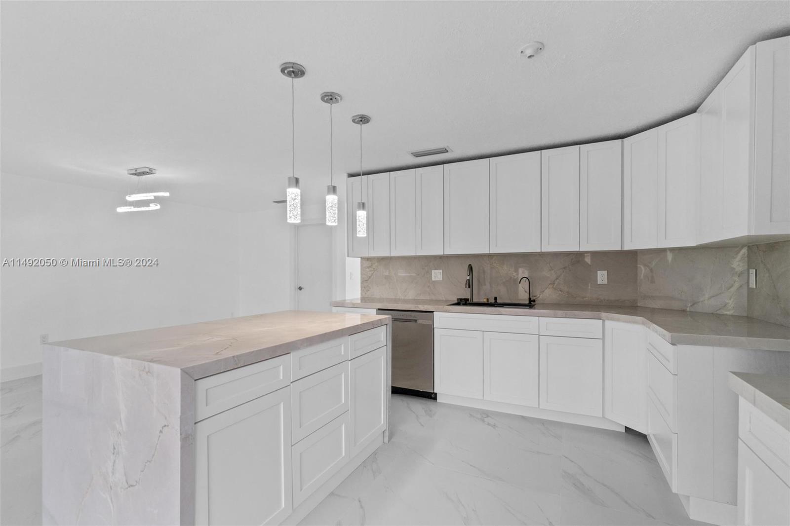 a kitchen that has a lot of cabinets in it with granite countertop stainless steel appliances