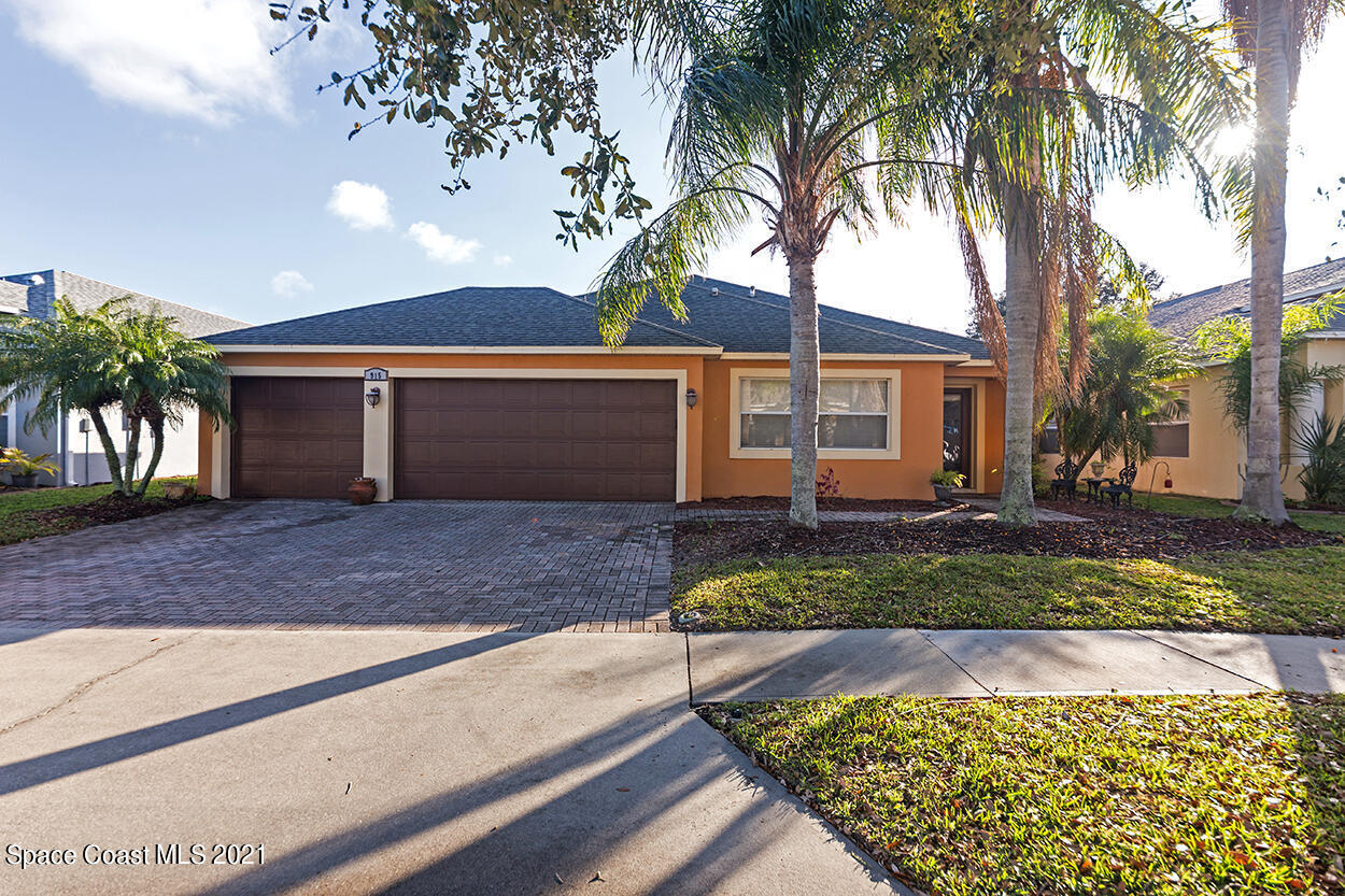 a front view of a house with a yard and a garage