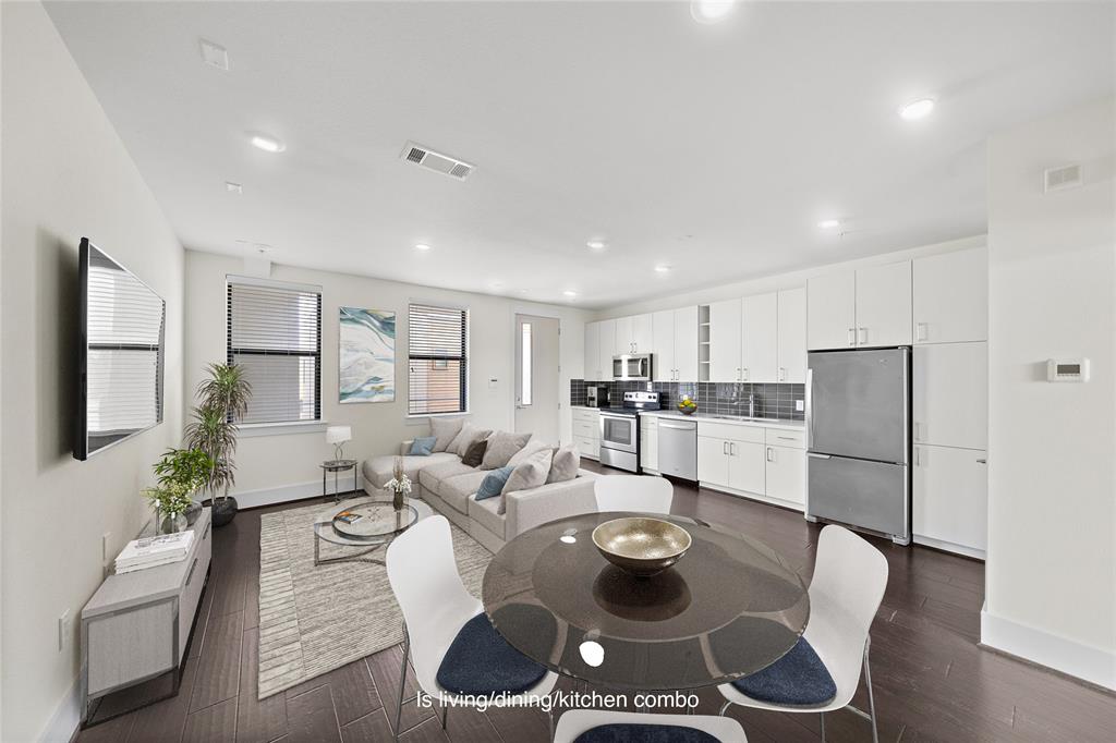 a living room with stainless steel appliances furniture dining table and chairs