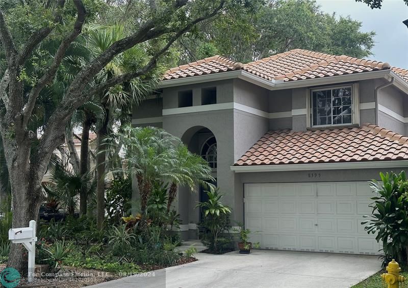 a front view of a house with plants