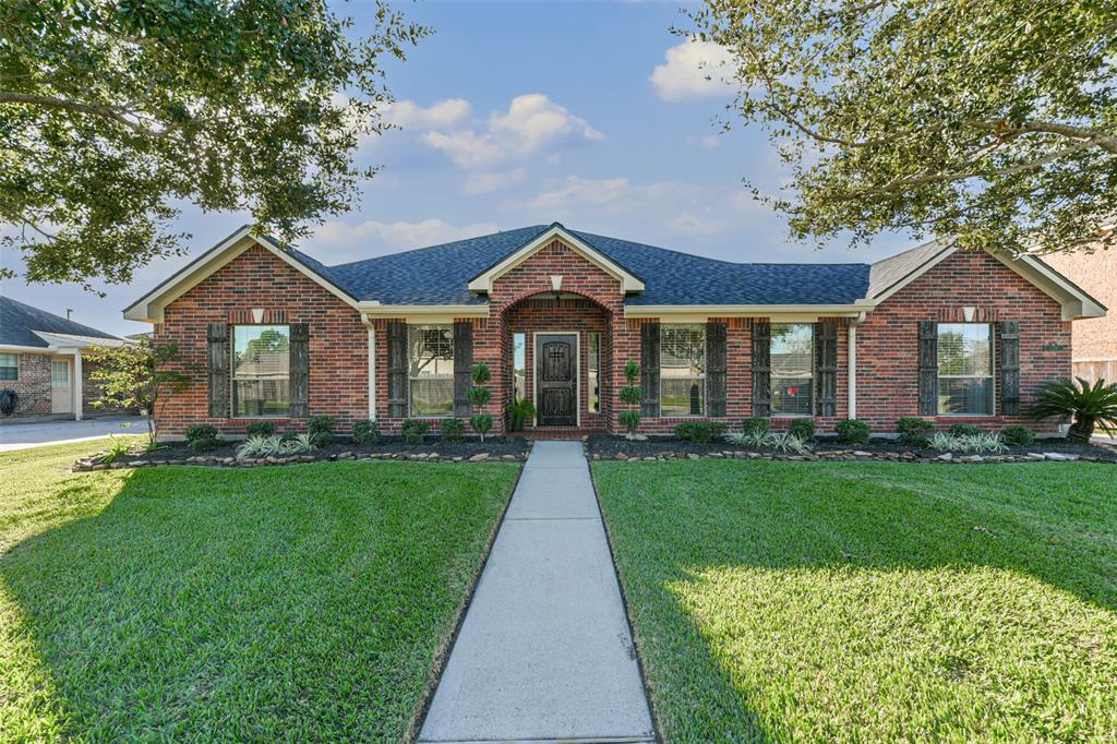 Welcome to this charming home, showcasing a distinctive knotty Alder front door with a unique iron-grilled speakeasy and complemented by elegant cedar shutters.