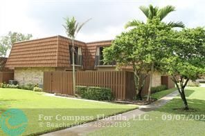 a view of a house with a yard and potted plants