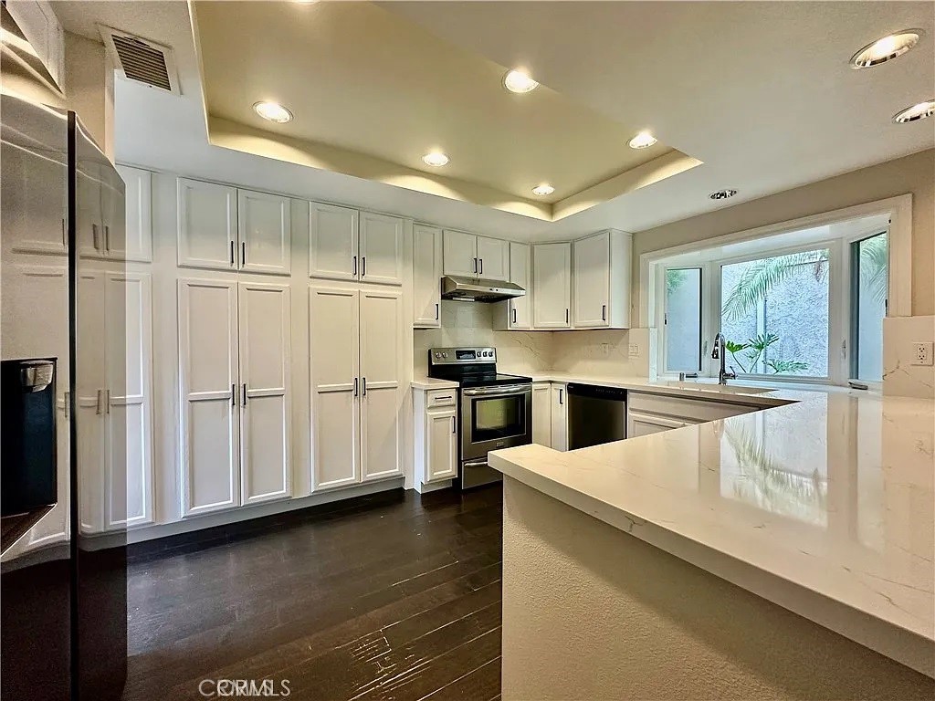 a kitchen with a refrigerator sink and cabinets