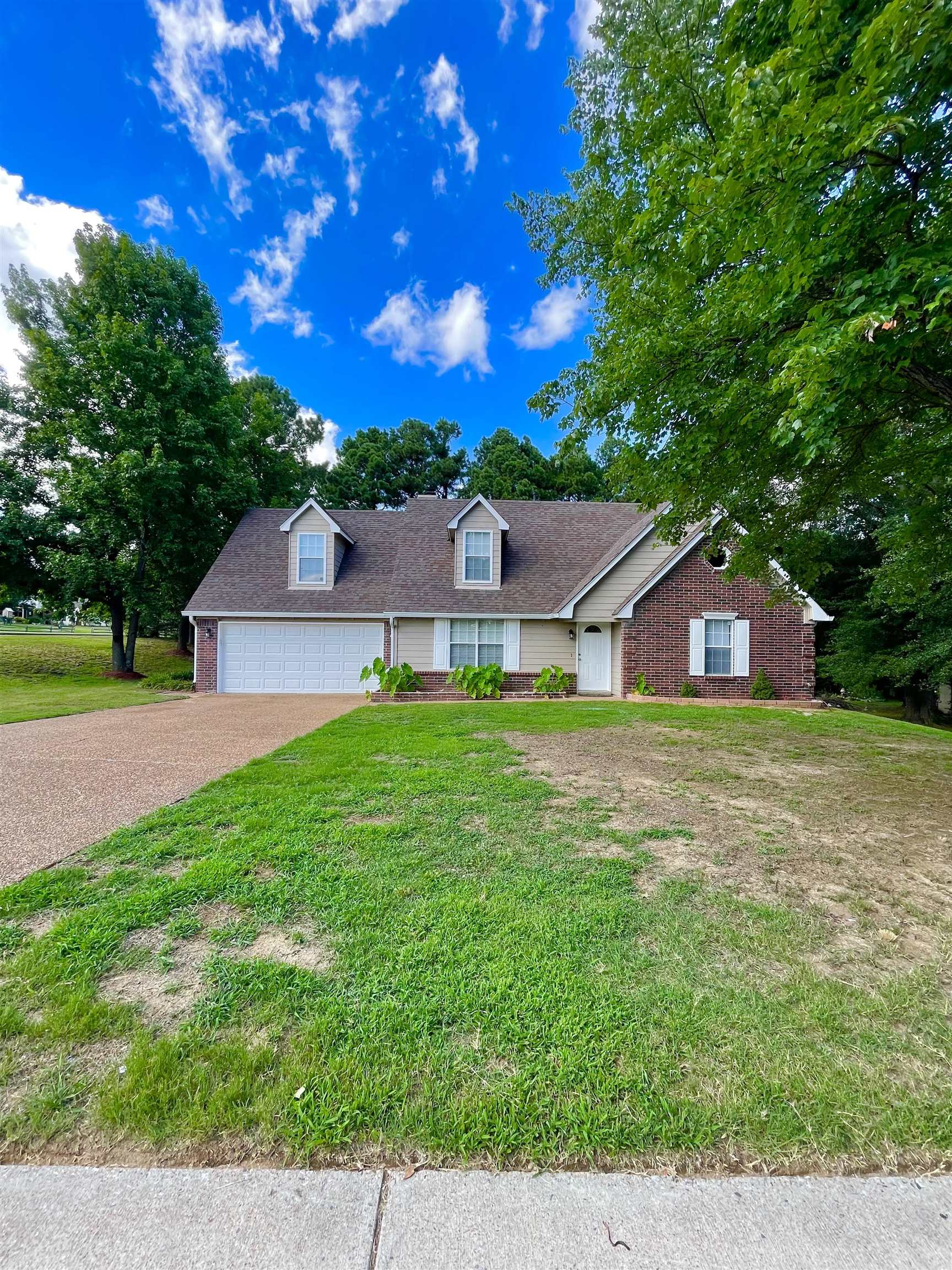 View of front of home with a garage and a front lawn