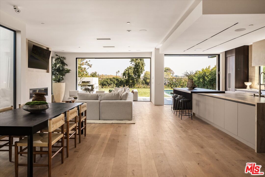 a kitchen with stainless steel appliances wooden floor dining table and chairs