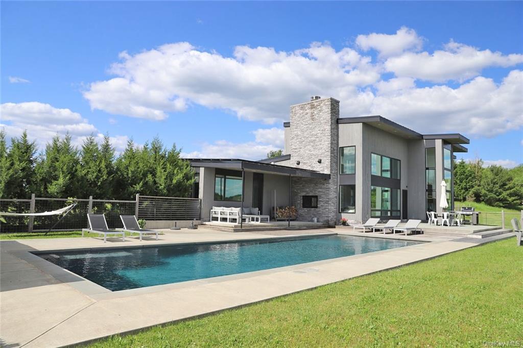 a view of house with swimming pool and outdoor seating