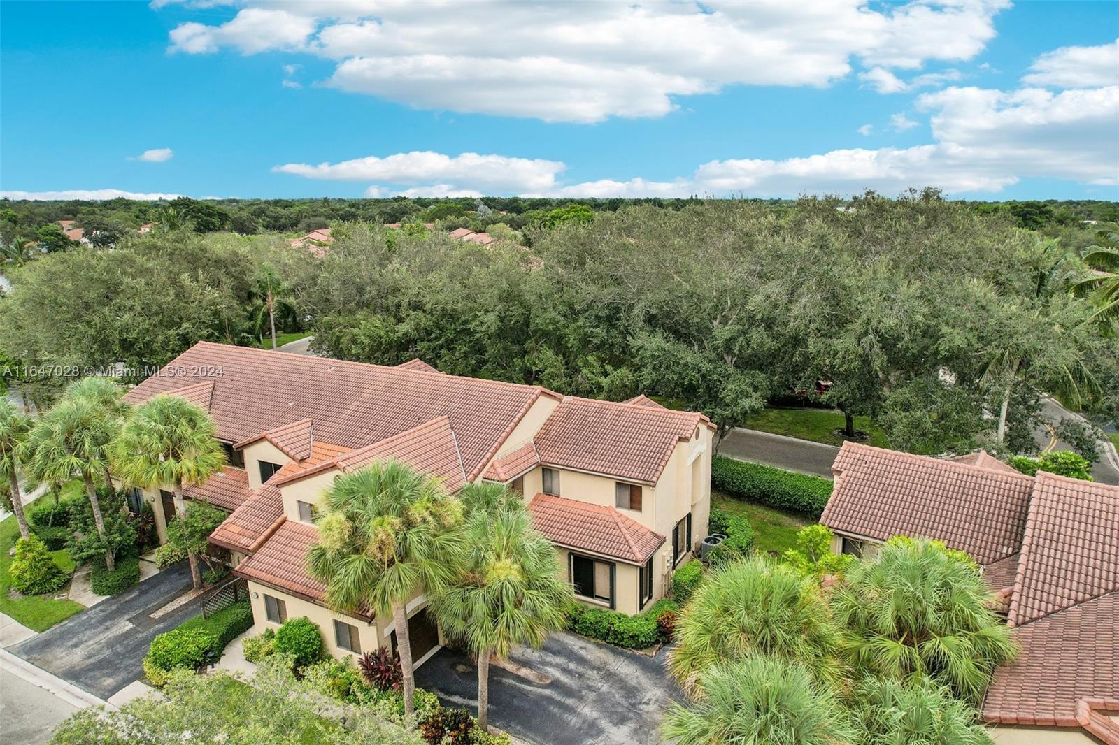 an aerial view of a house with green landscape