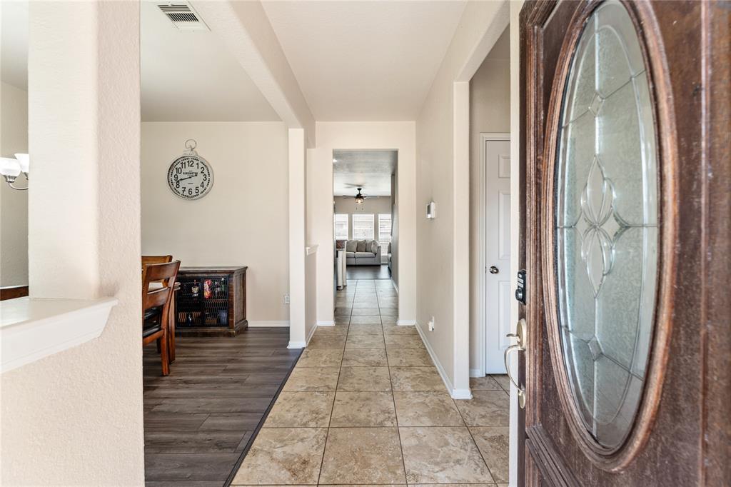 a view of a hallway with wooden floor and a bathroom