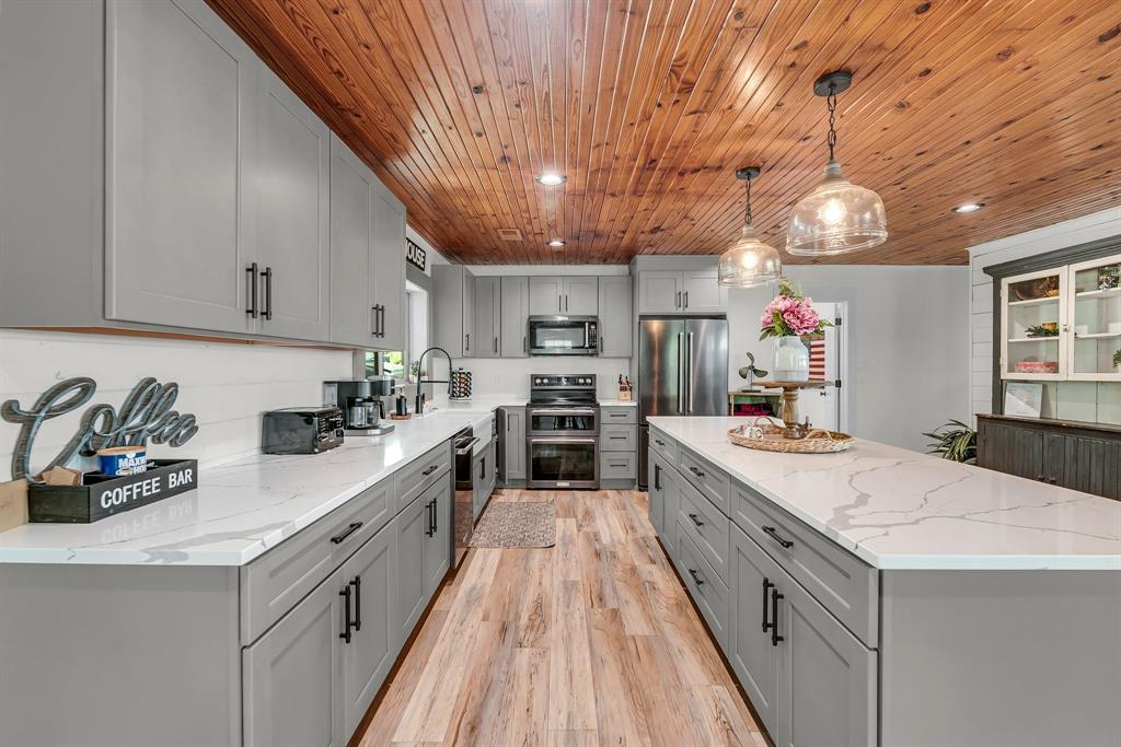 a large kitchen with stainless steel appliances granite countertop a lot of counter space