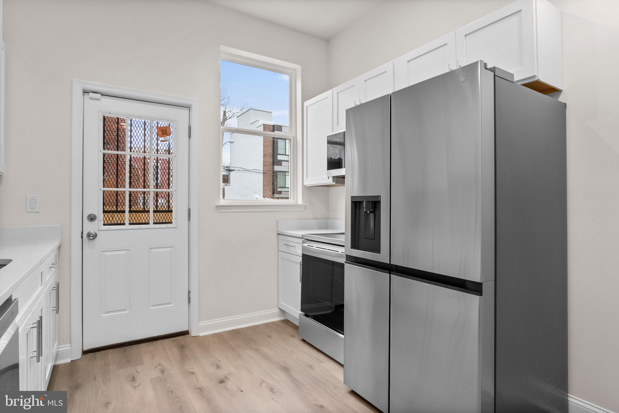 a kitchen with stainless steel appliances granite countertop a refrigerator and a stove top oven