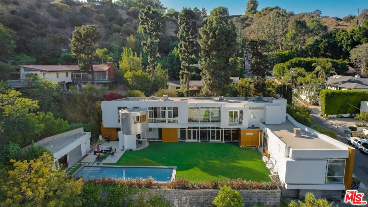 a view of a house with a backyard and sitting area