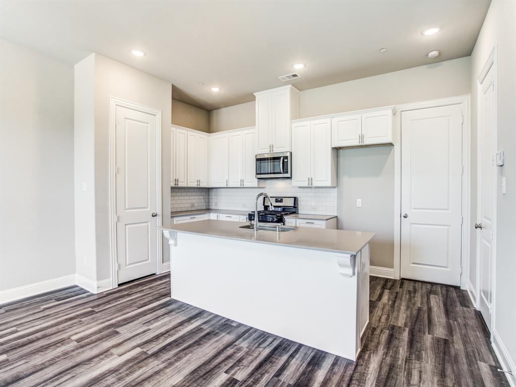 a kitchen with kitchen island a sink stove and refrigerator