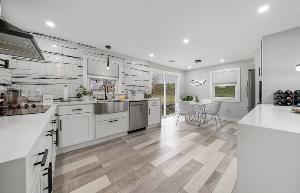 a kitchen with white cabinets and sink