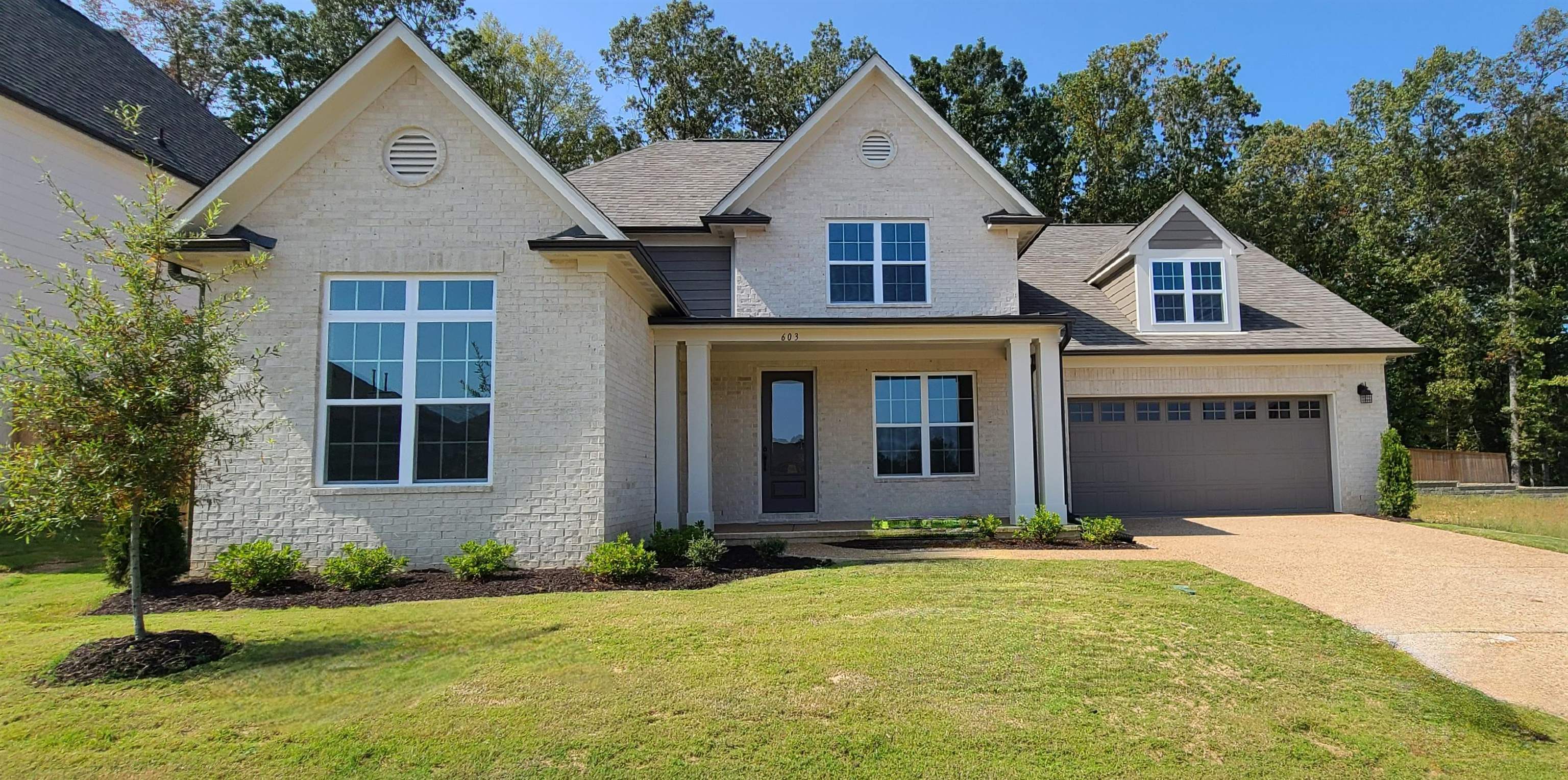 a front view of a house with a yard and garage