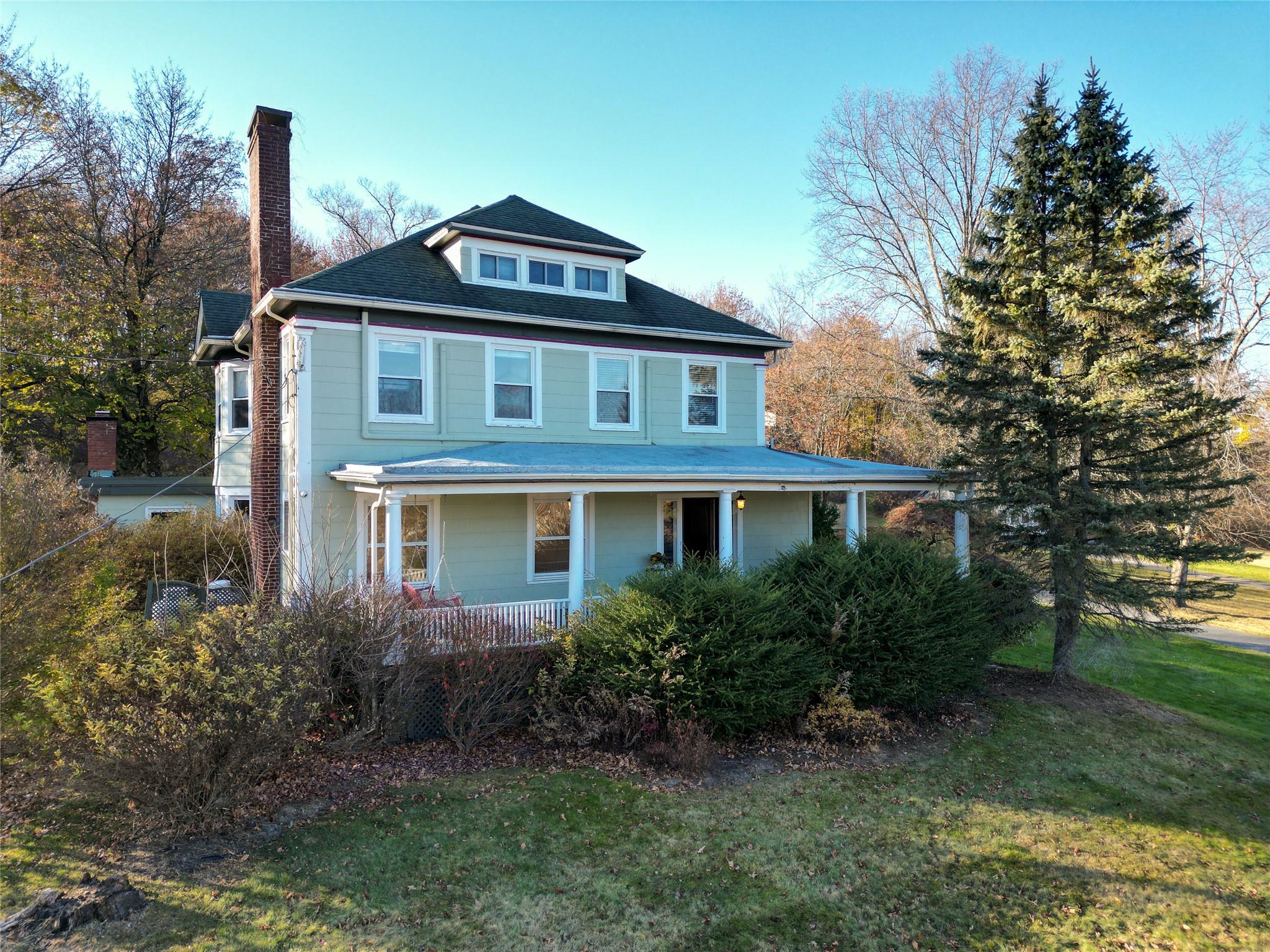 View of front facade featuring a front lawn and a porch