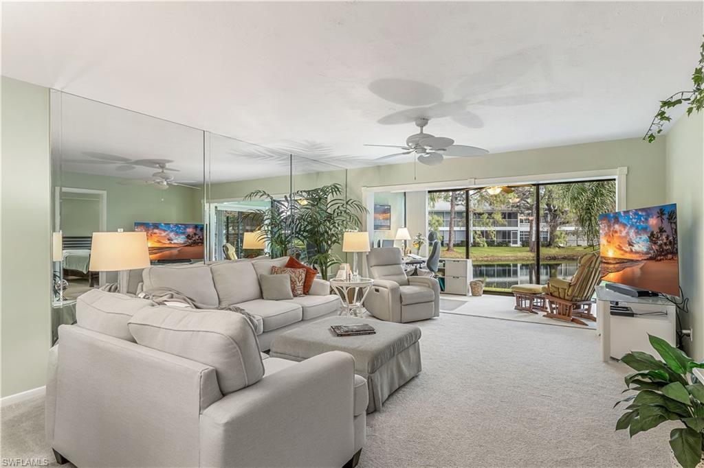 a living room with furniture and a large window with garden view