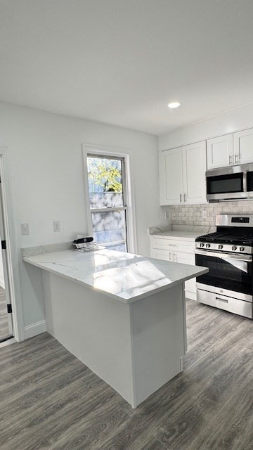 a kitchen with stainless steel appliances a stove a sink and a microwave