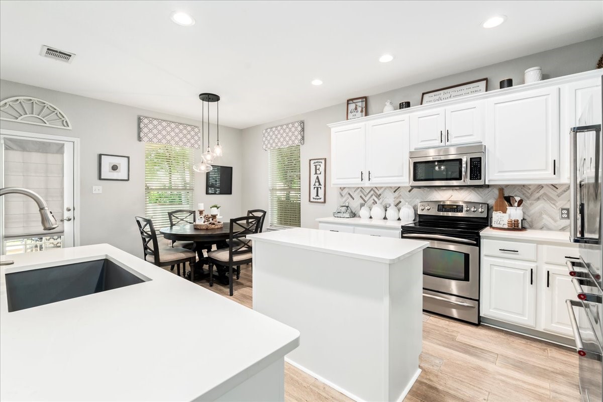 a kitchen with a sink a stove top oven and refrigerator