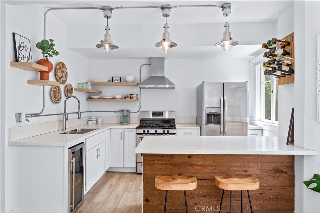 a kitchen with kitchen island stainless steel appliances a sink and a stove