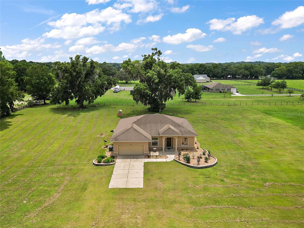 an aerial view of a house with a garden and trees