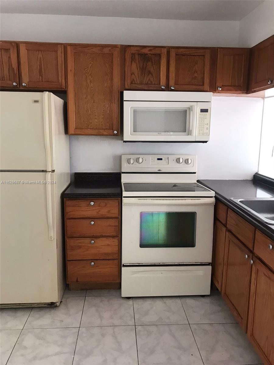 a kitchen with cabinets and white appliances