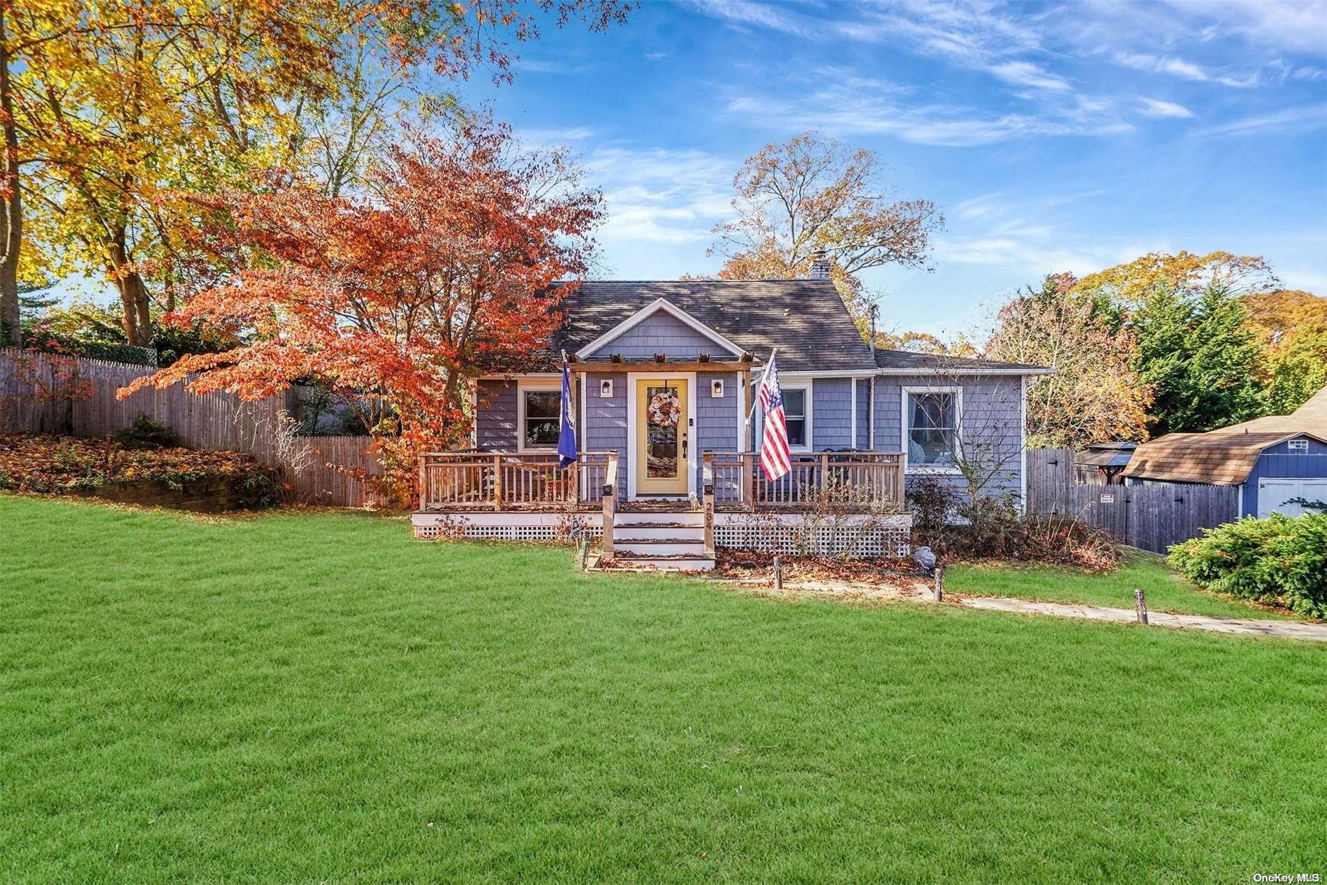 a front view of a house with garden and tree