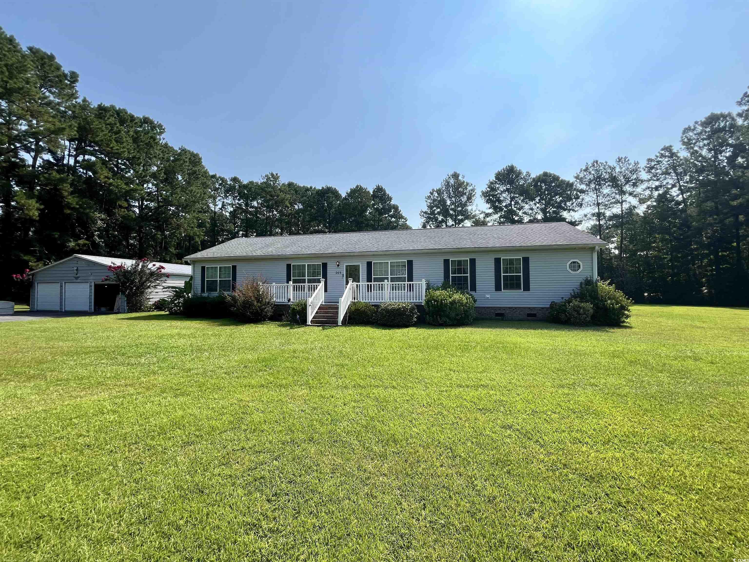 Ranch-style house with a garage, an outbuilding, a