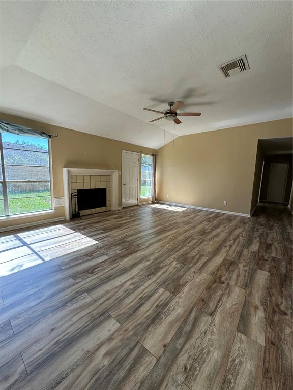 a view of empty room with wooden floor and fireplace