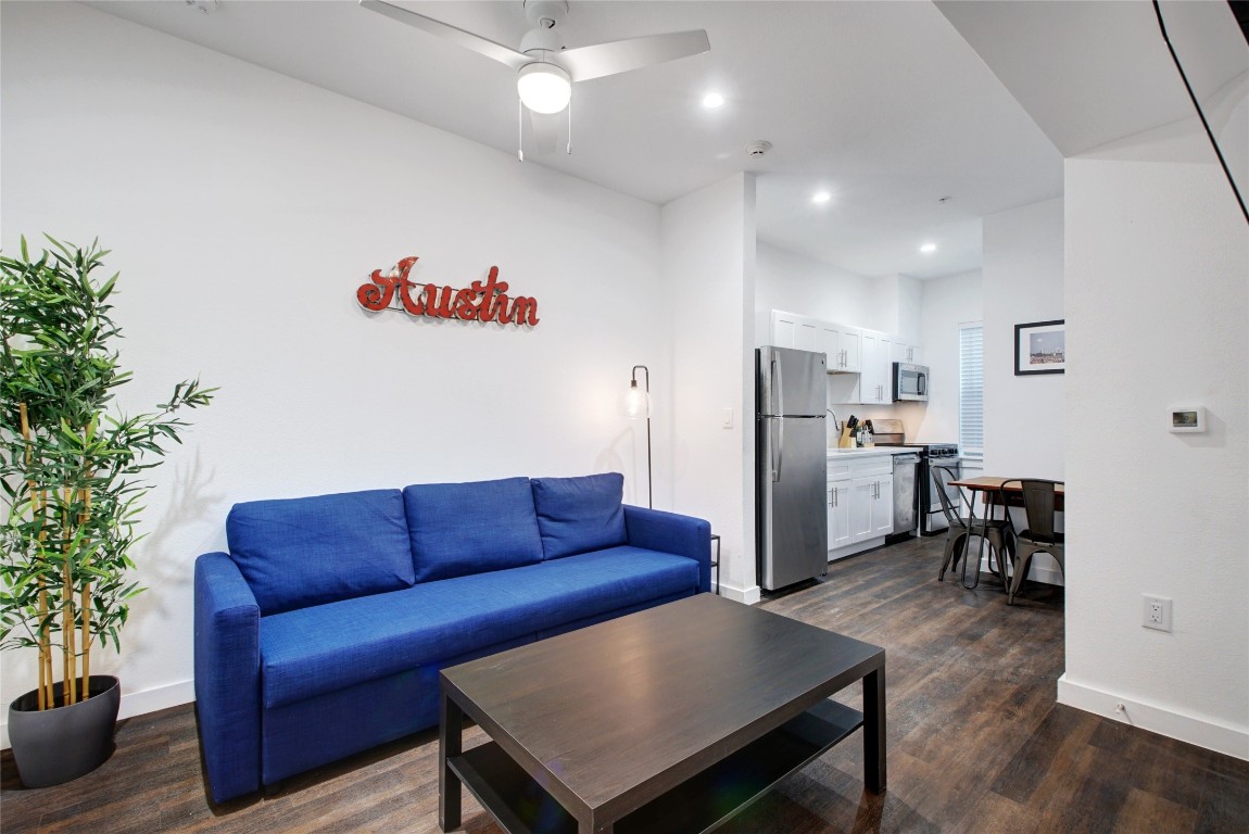 a living room with furniture a refrigerator and a couch