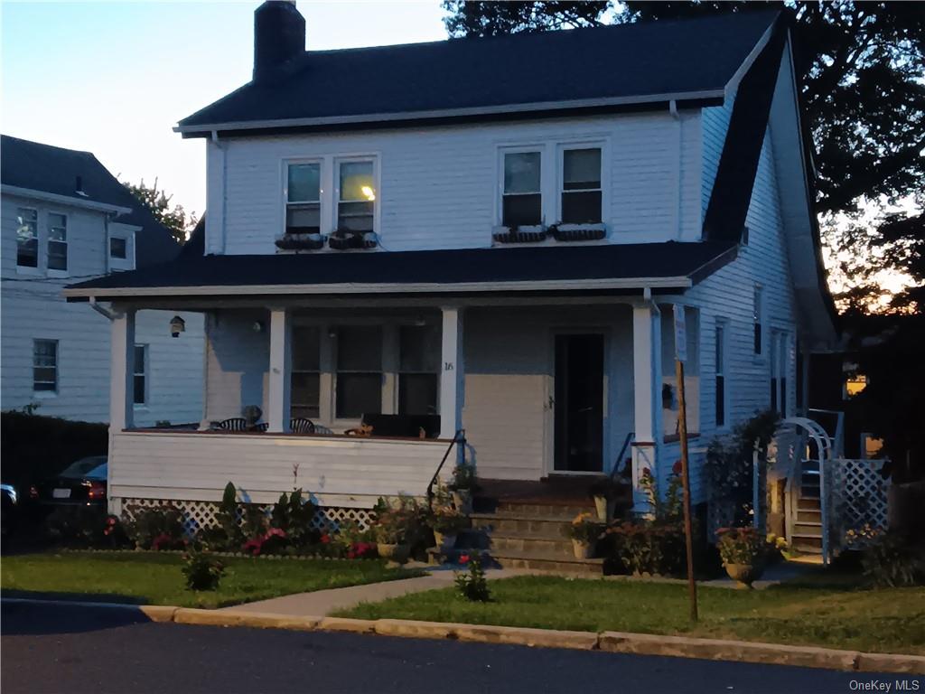 View of front facade featuring a porch and a lawn