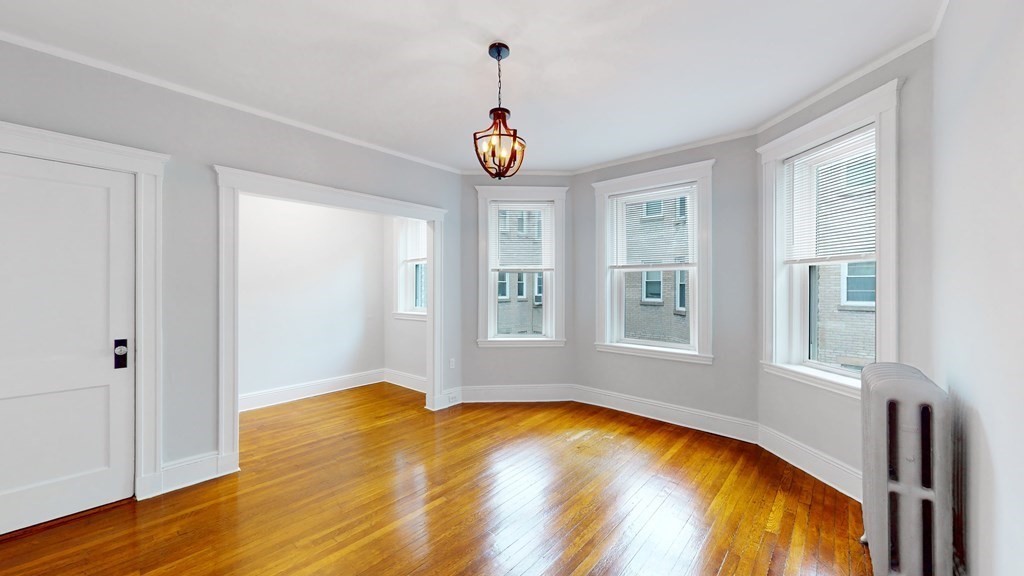 an empty room with window and wooden floor