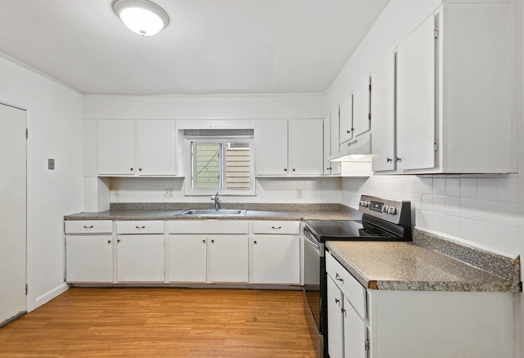 a kitchen with stainless steel appliances granite countertop a sink and a white cabinets