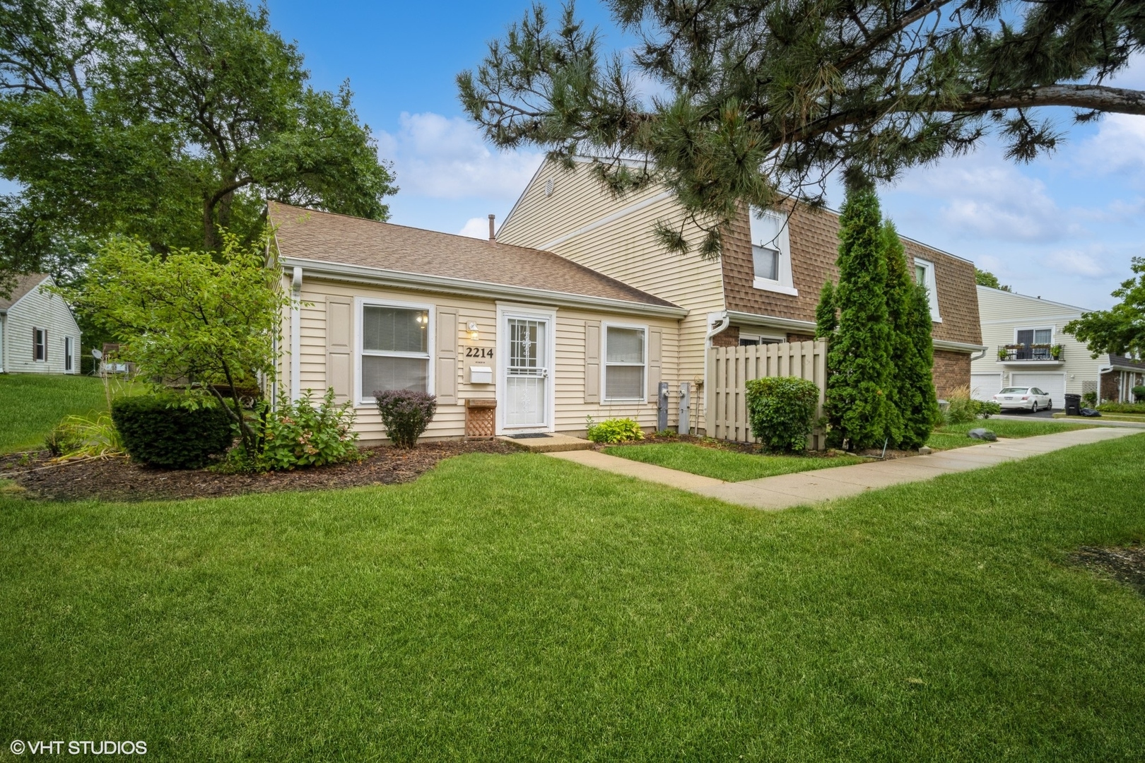 a front view of a house with a yard and potted plants