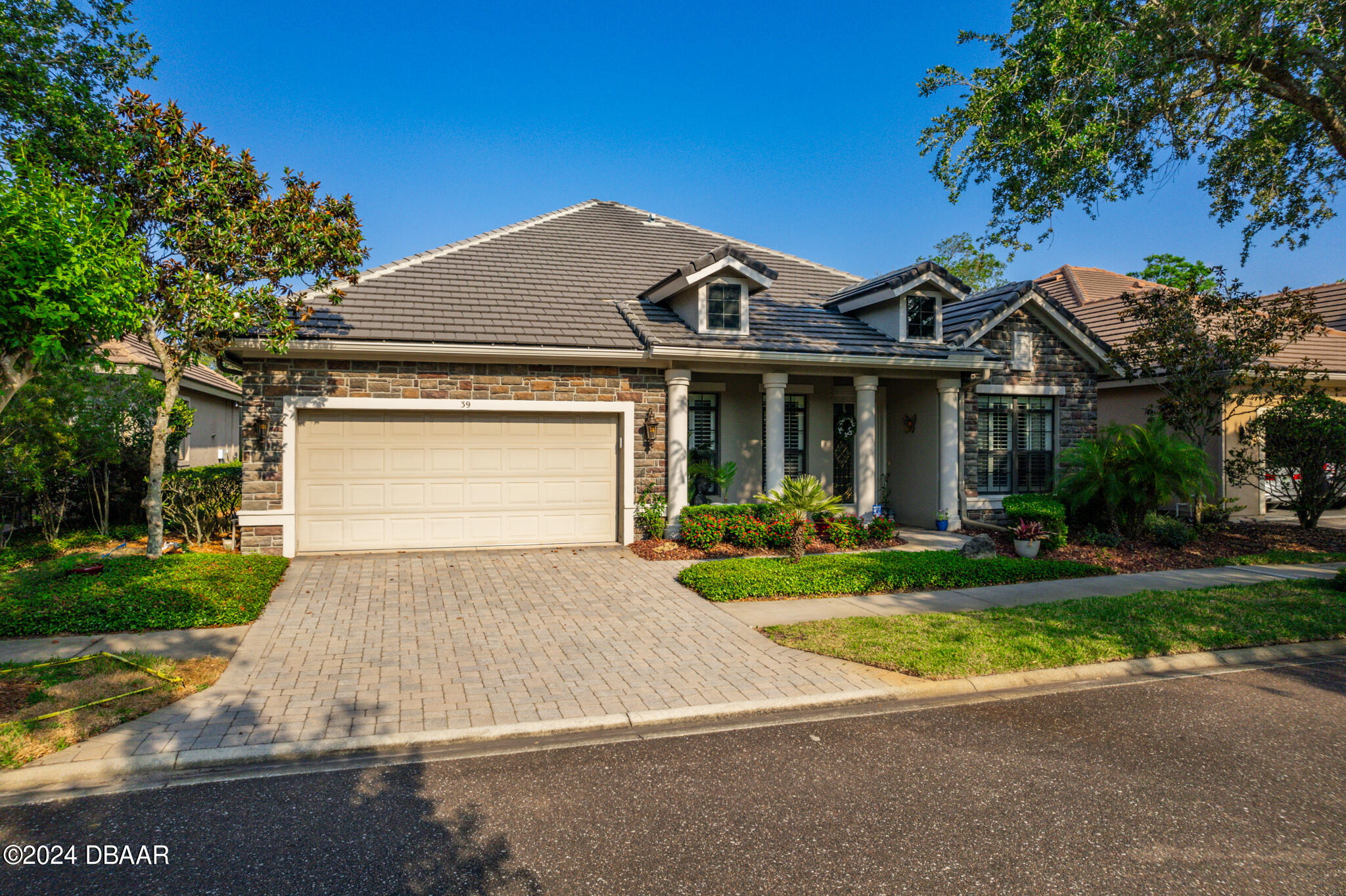 a front view of a house with yard and green space