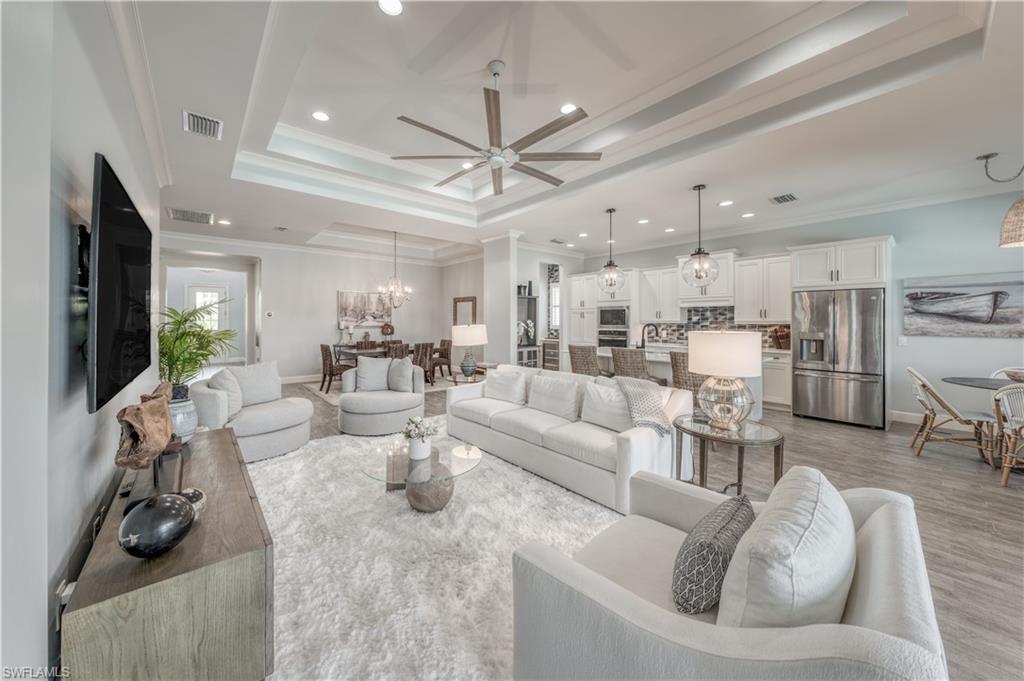 a living room with furniture a flat screen tv and a large window