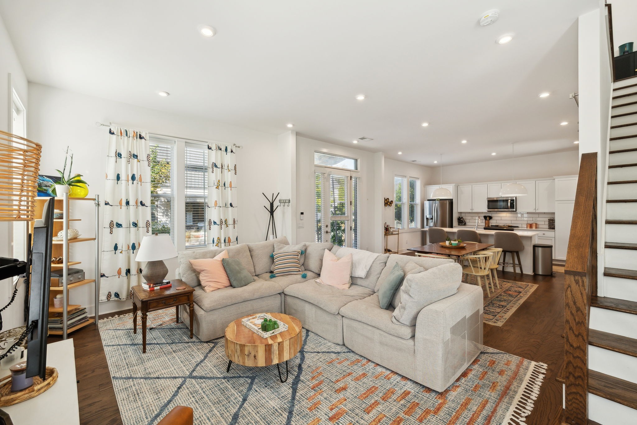 a living room with furniture kitchen view and a chandelier