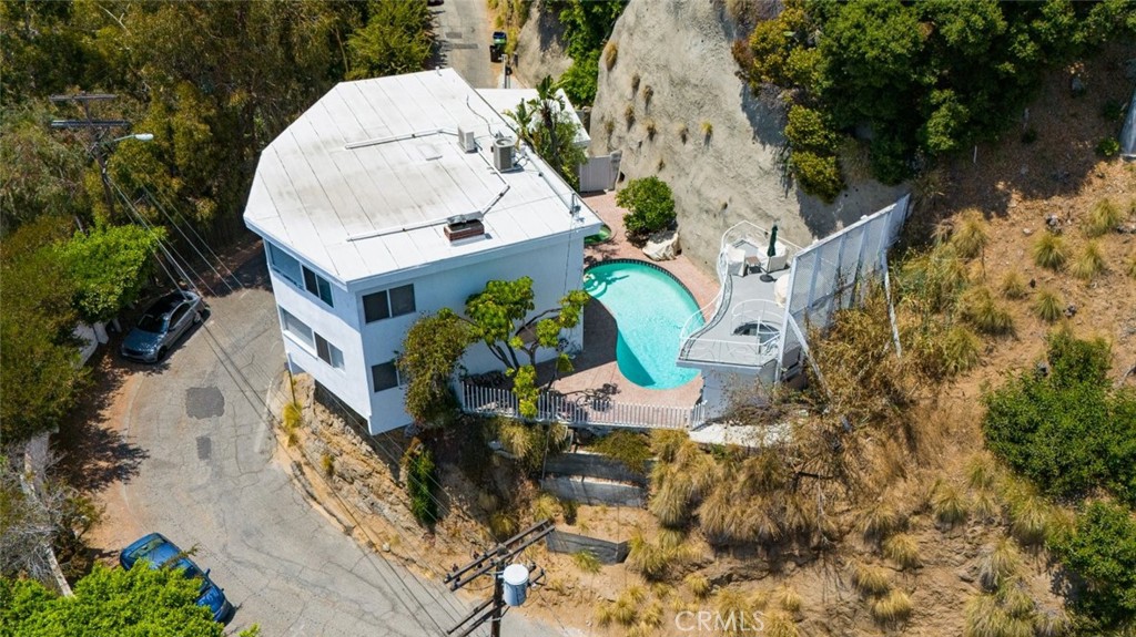 an aerial view of a house with a yard and large trees