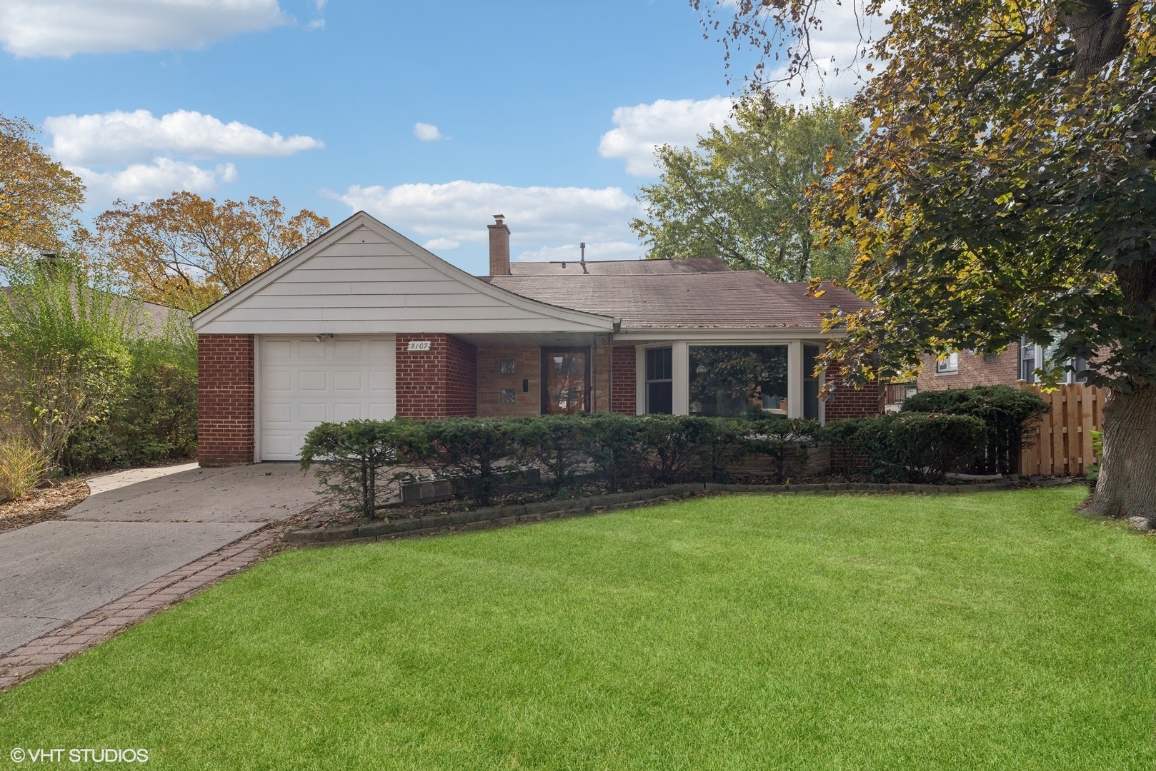 a front view of a house with a garden and yard