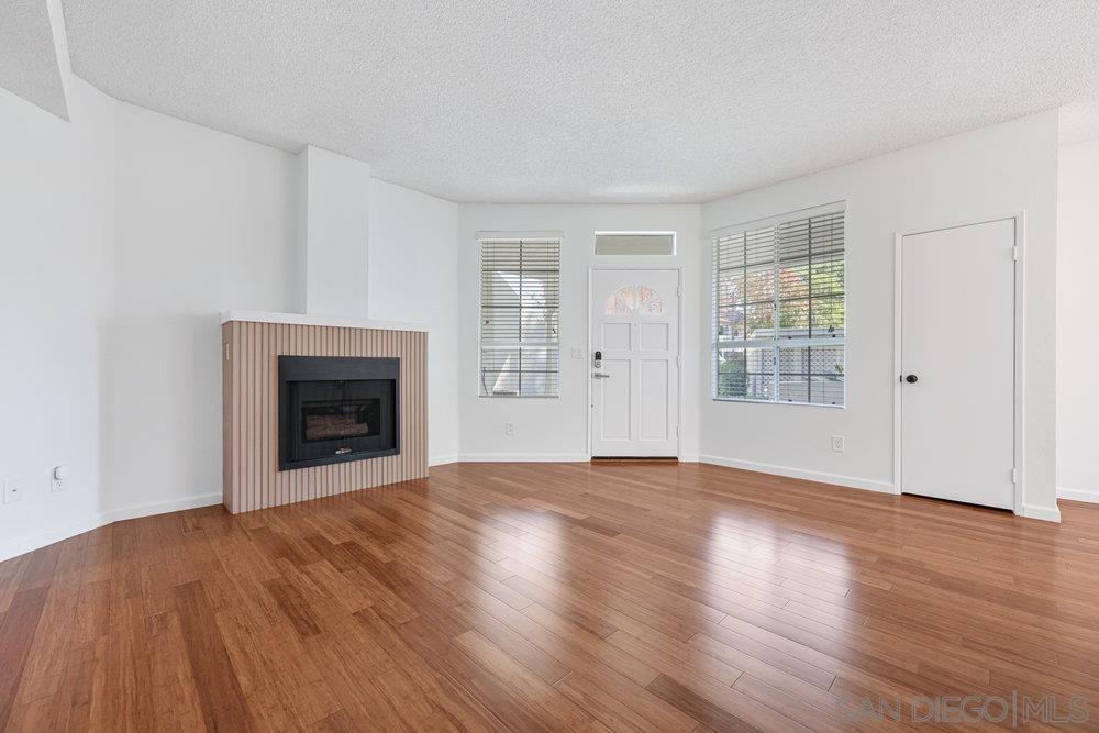 an empty room with windows and fireplace