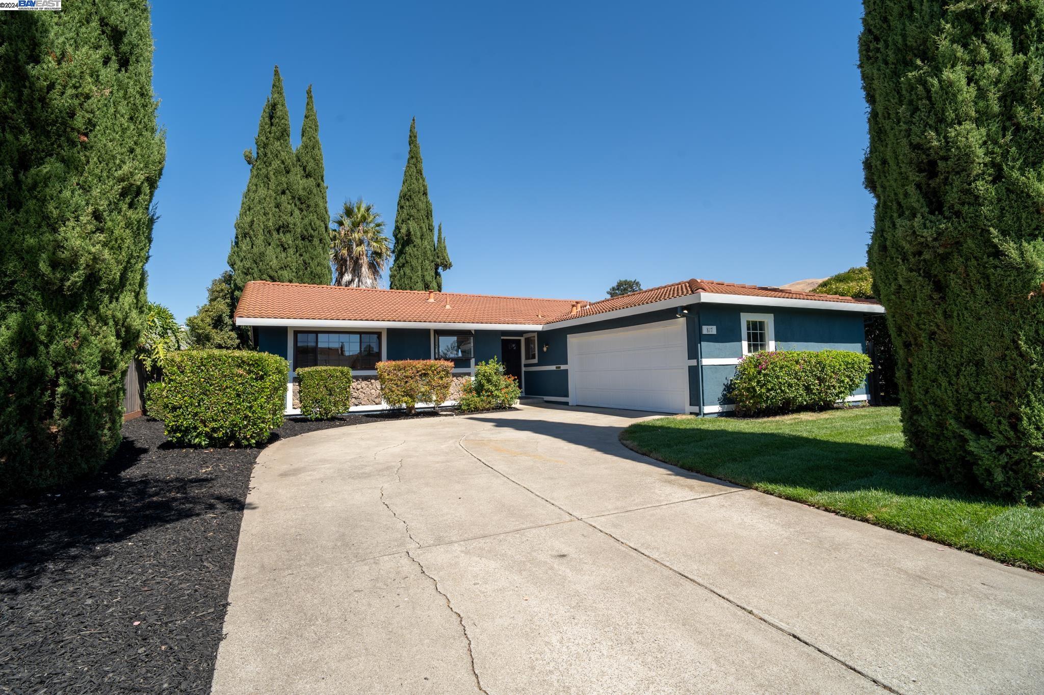 a front view of a house with yard and green space