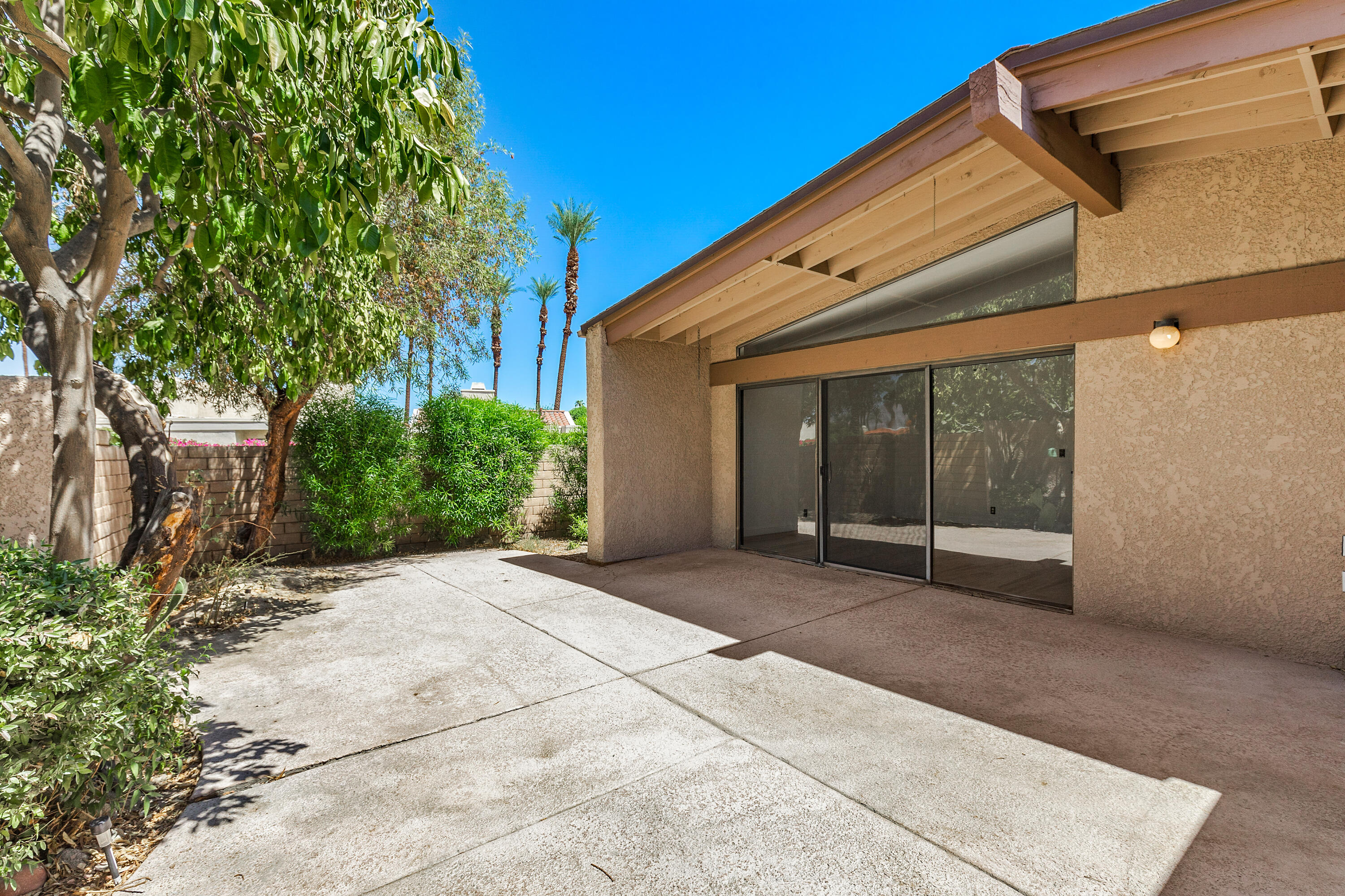 a backyard of a house with garden and outdoor seating