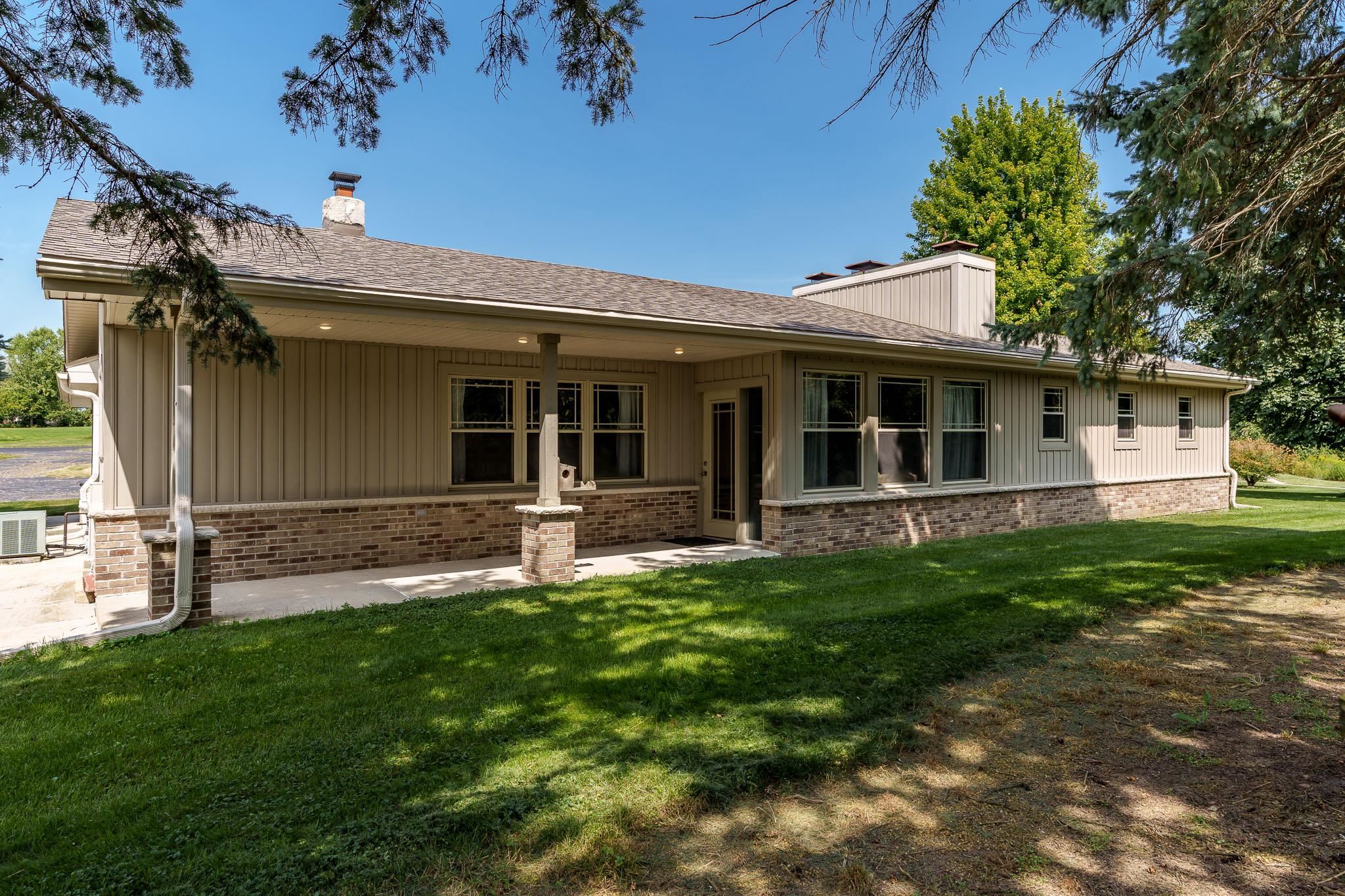 a view of a house with a yard and sitting area