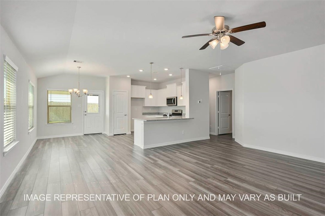 Unfurnished living room featuring ceiling fan with